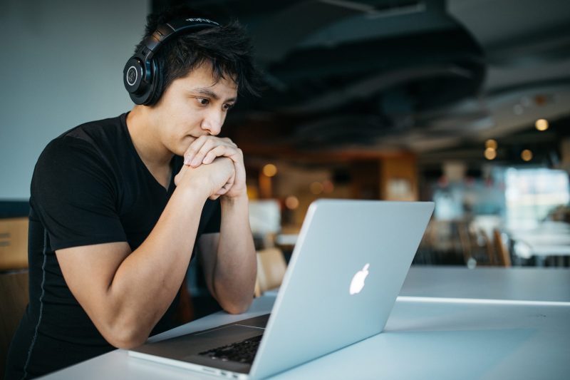 Man looking at laptop with headphones