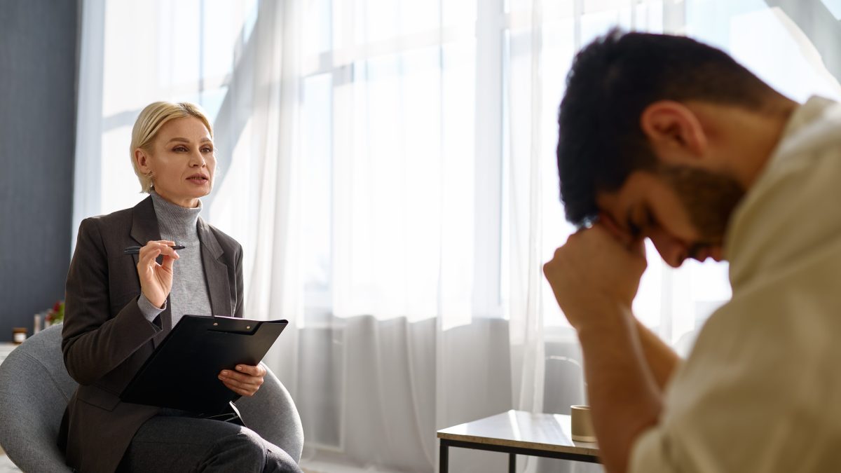 Psychologist talking to depressed frustrated unhappy man