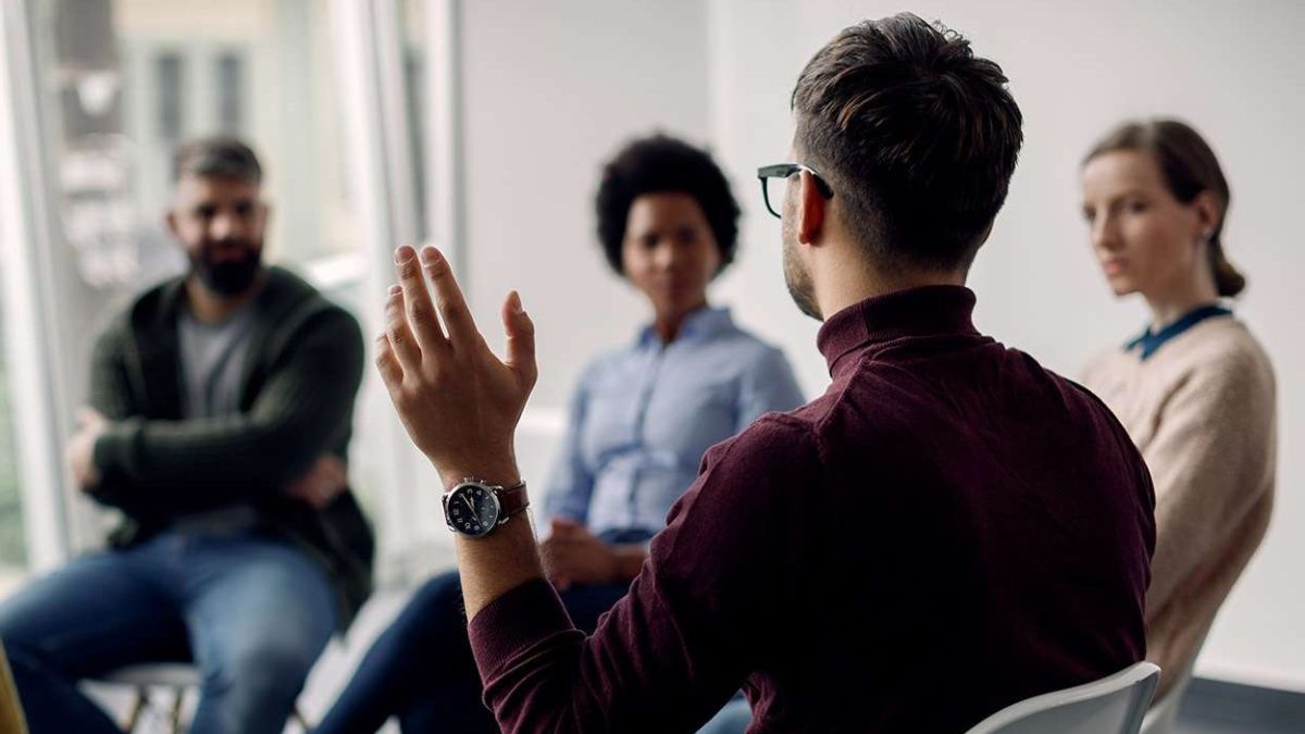 Rear view of man with raised hand on group therapy in medical center.|Pros (2)|Specialisations at CATCH (1)|Pros (2000 × 1500px)|1|2|Individual CBT & DBT therapy (1)|Untitled design (1)|Untitled design (2)|Pros (2000 × 1500px) (1)|Horizontal services and goals|grup therapy session holding hands