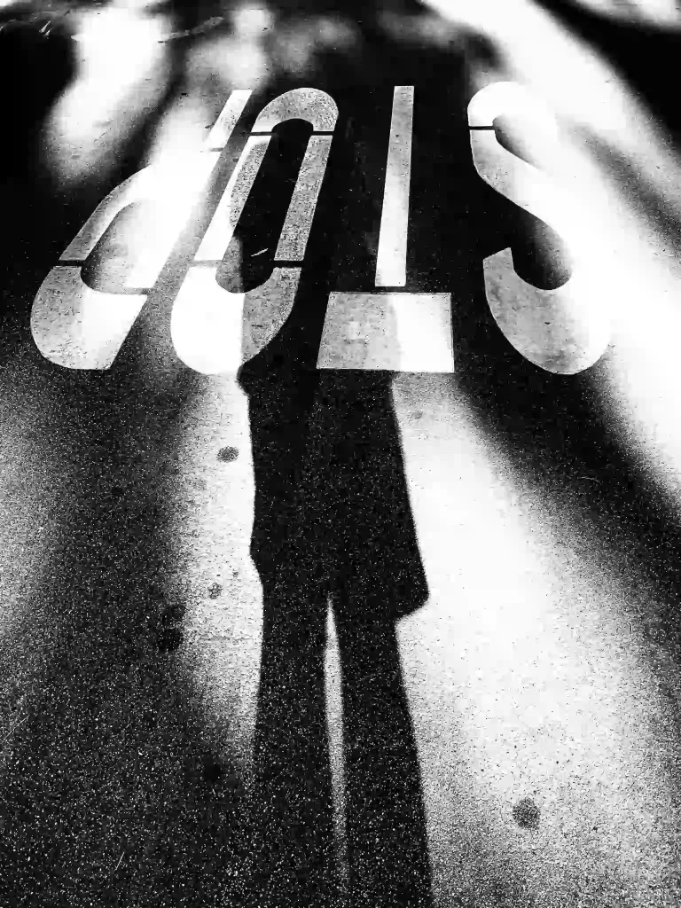 setting boundaries stop photo with a human shadow and a sign on the road