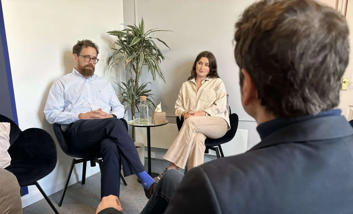 Two people talking to a therapist during addiction therapy.