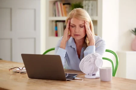 A woman trying to cool down after having an alcohol hot flush.